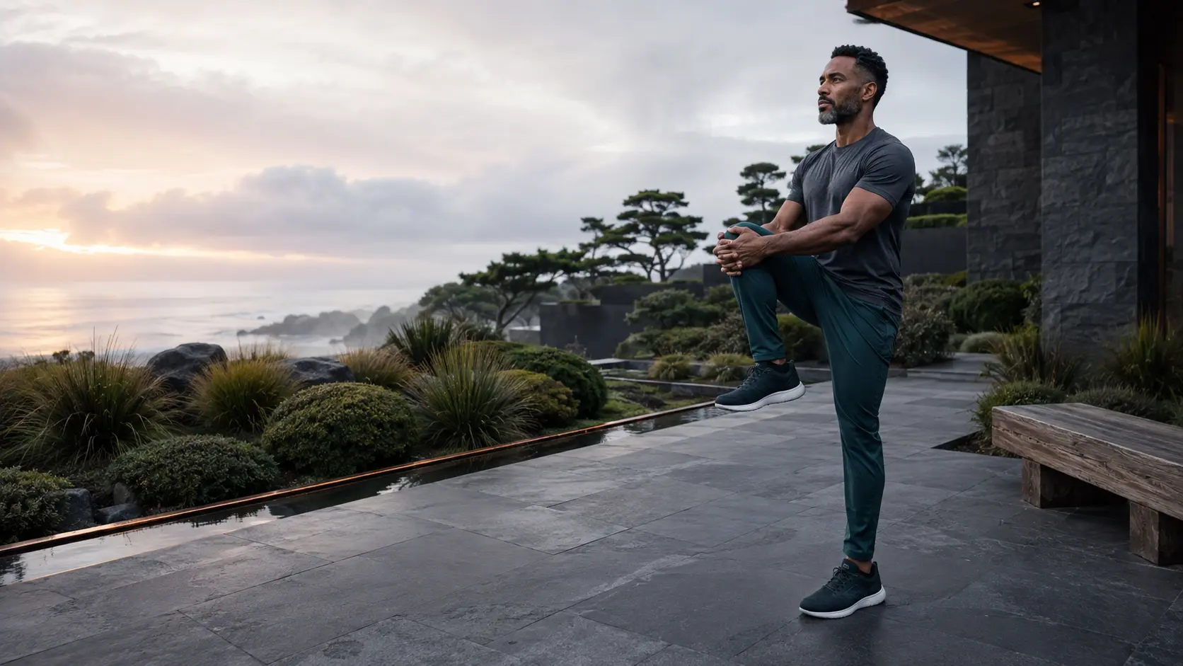 A Black man practicing controlled mobility in a masculine coastal garden